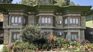 A traditional building with ornate window frames and a green roof.