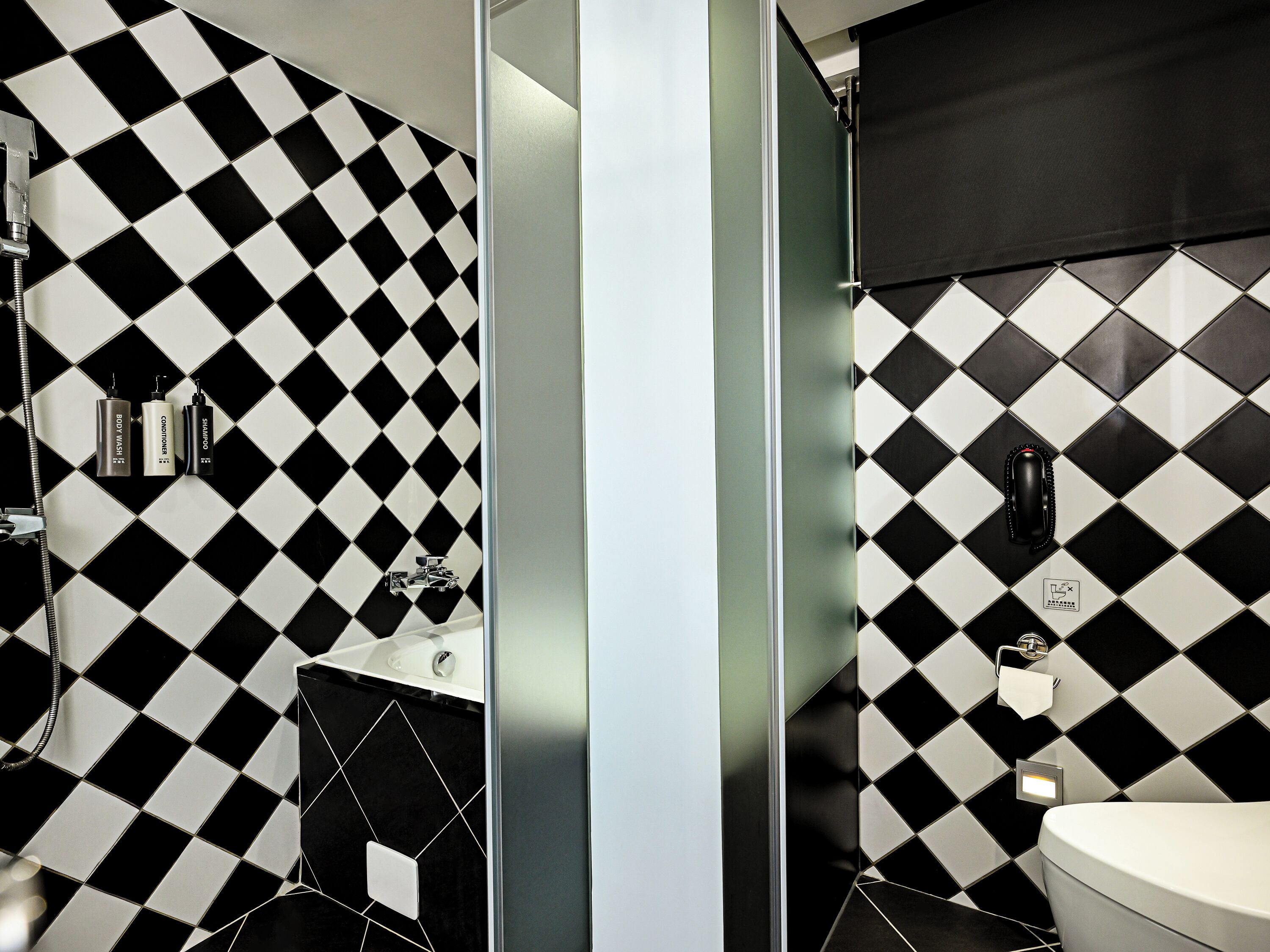 A bathroom with a black and white checkered tile pattern, a white sink, and a toilet.