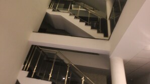 A multi-level interior with a staircase and a lit wall feature. - Garden Zara Hotel (Zara)