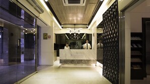 A hotel reception area with a marble counter, a reception desk, and a modern chandelier. - Wallsun Hotel (Taipei)