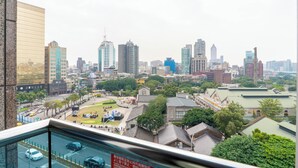 A cityscape with modern buildings, a park, and a view from a high vantage point. - Wallsun Hotel (Taipei)