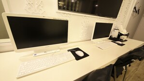 Et rent, moderne arbejdsområde med to skærme, et tastatur og en mus på et hvidt skrivebord.