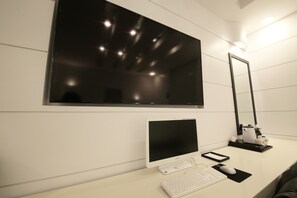 A modern room with a large window, a desk with a computer, keyboard, mouse, and a mirror. - Premium AVA Hotel Sasang (Busan)