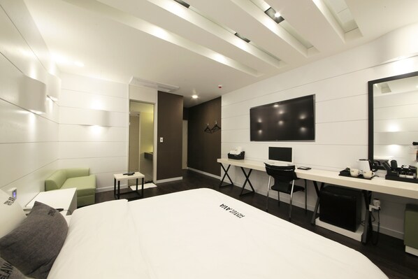 A modern hotel room with a large bed, a desk, a chair, and a mirror. - Premium AVA Hotel Sasang (Busan)