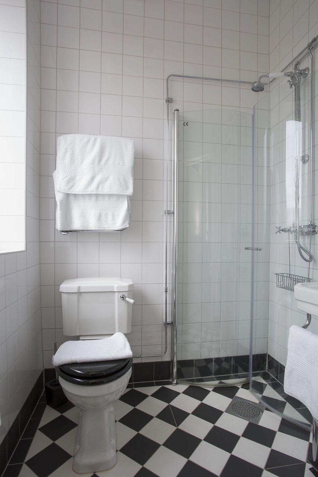 A bathroom with a toilet, a shower, and a sink.