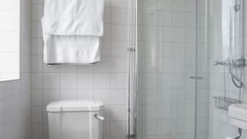 A bathroom with a toilet, a shower, and a sink.