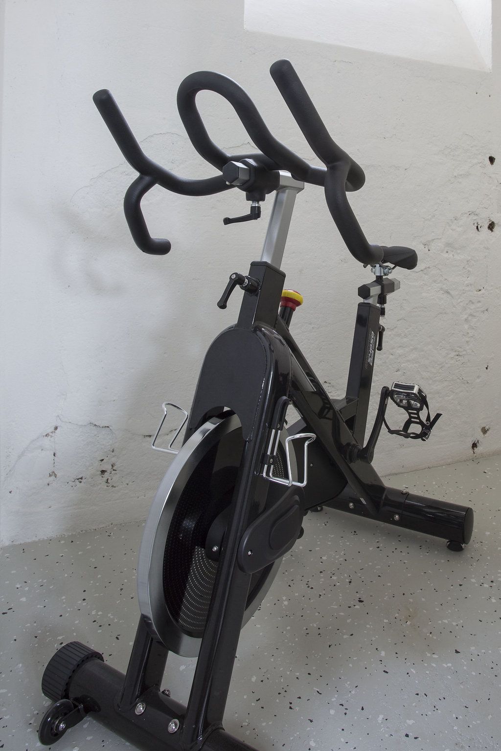 Una bicicleta estática con pantalla digital, manillar y pedales.