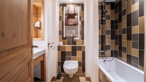 Une salle de bain avec des toilettes, un lavabo et une douche.