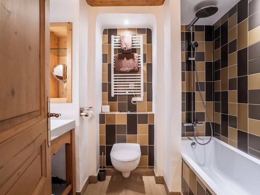 A bathroom with a toilet, sink, and shower.