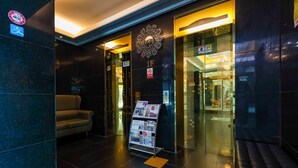 A lobby with a reception desk, a seating area, and an elevator. - Charlot Castle Hotel (Pyeongtaek)