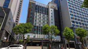 A modern hotel with a prominent sign, multiple floors, and a parking area. - Charlot Castle Hotel (Pyeongtaek)