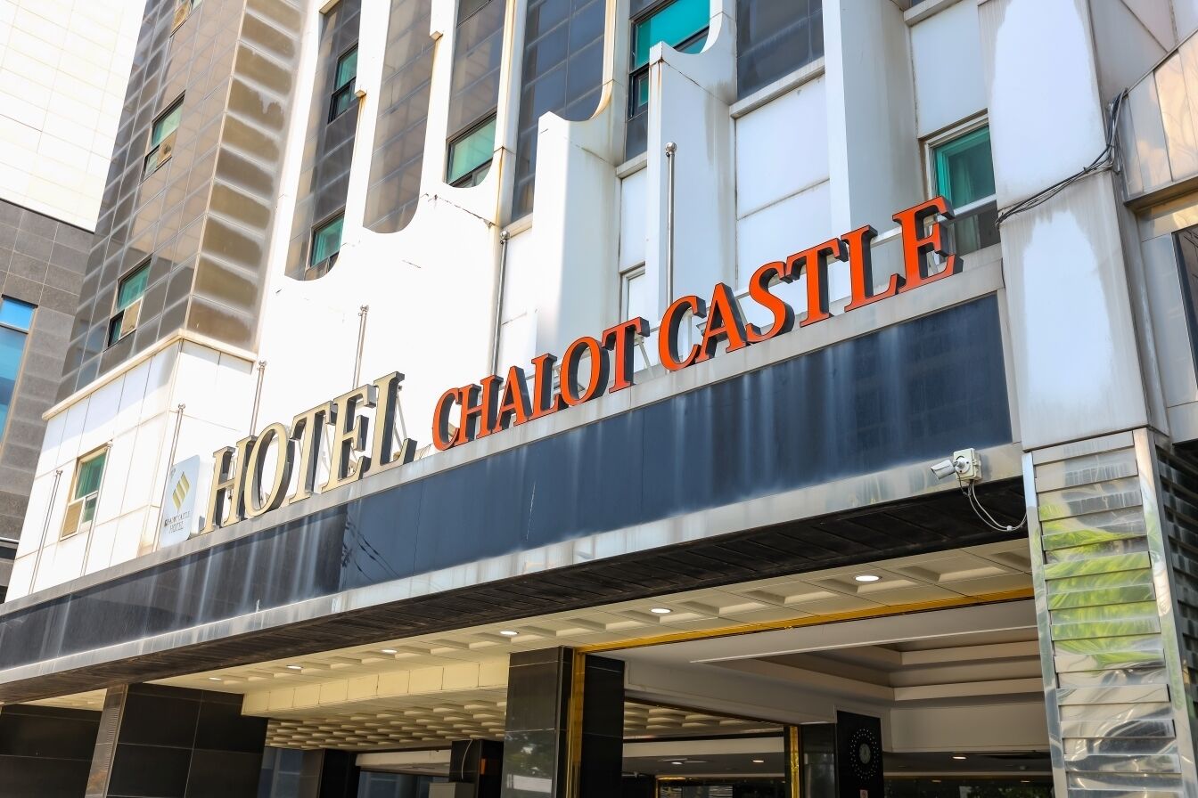 The exterior of the HOTEL CHALOT CASTLE with a prominent sign and a modern architectural design.