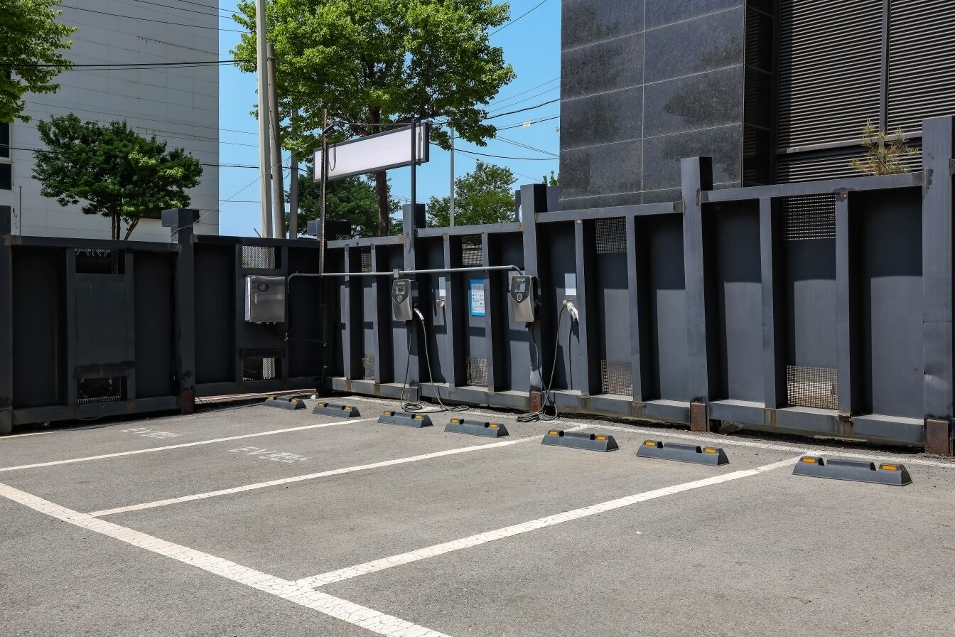 A parking area with marked spaces and a gated entrance.