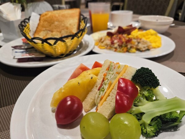 Un plato de desayuno con tostadas, huevos, tocino y verduras.