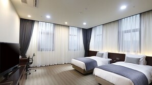 A hotel room with two beds, a TV, a desk, and a chair. - Geosung Hotel (Eumseong)