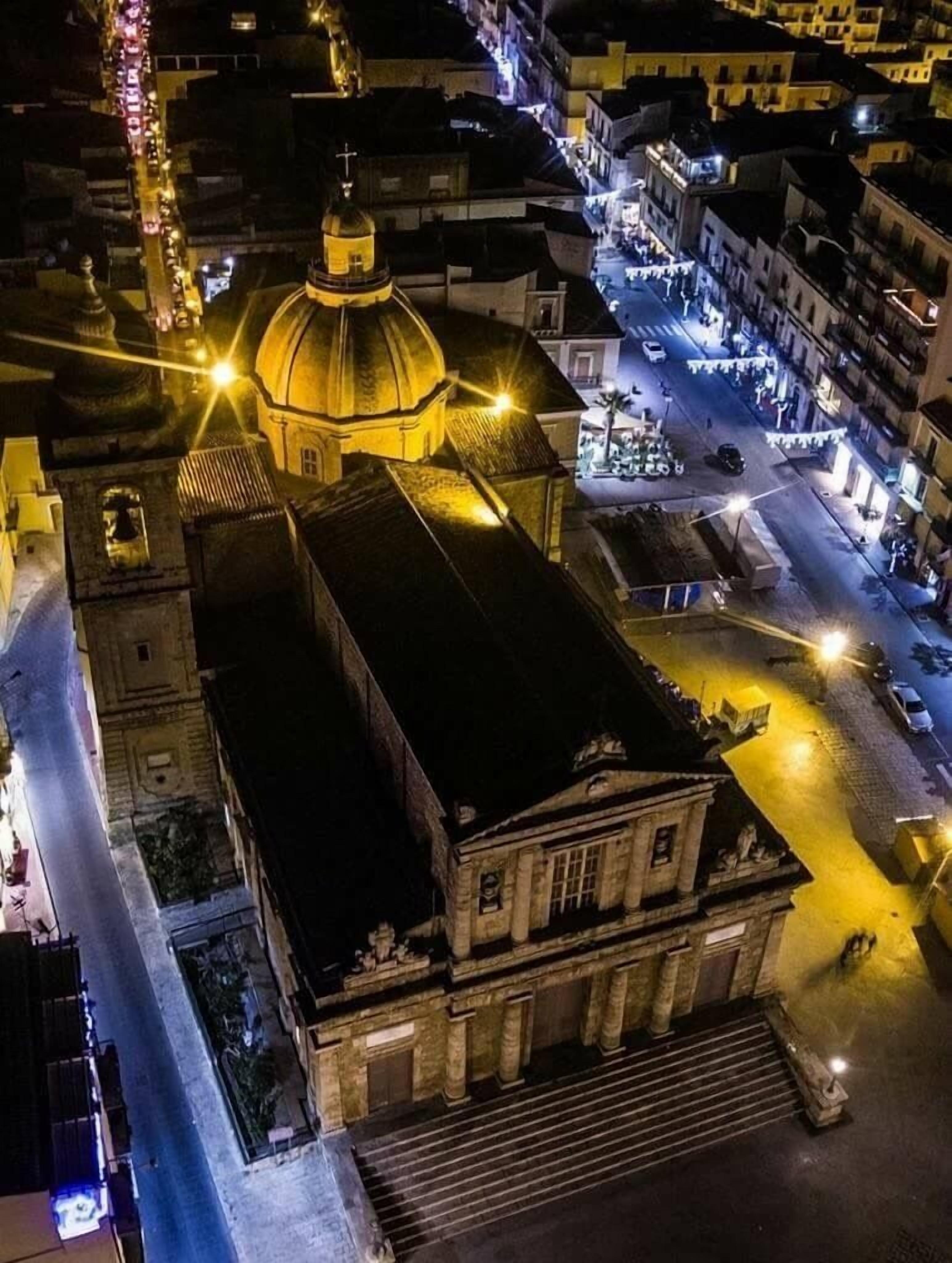Un bâtiment historique doté d’un dôme imposant et d’une architecture classique, situé dans une rue de la ville, entouré d’autres bâtiments.