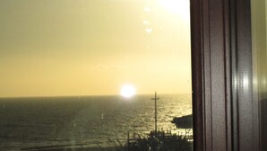 A view of the ocean with a sunset, a pier, and a cross structure. - B&B Elisir (Gela)