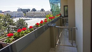 Un balcón con flores rojas y vistas a un edificio histórico.