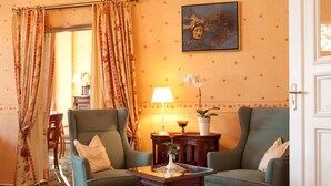 A room with two green armchairs, a small wooden table with a vase and a lamp, and a painting on the wall. - Safestay Berlin Kurfurstendamm (Berlin)