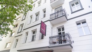 A multi-story building with a white facade, multiple balconies with metal railings, and a prominent sign for 'safestay'. - Safestay Berlin Kurfurstendamm (Berlin)