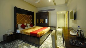 Una habitación de hotel con cama, mesita de noche y escritorio con silla.