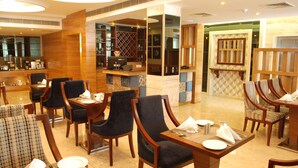 A restaurant with wooden furniture, a bar area, and a seating arrangement. - Glades Hotel (Mohali)