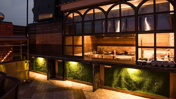 A modern kitchen with large windows and a brick exterior. - Glades Hotel (Mohali)