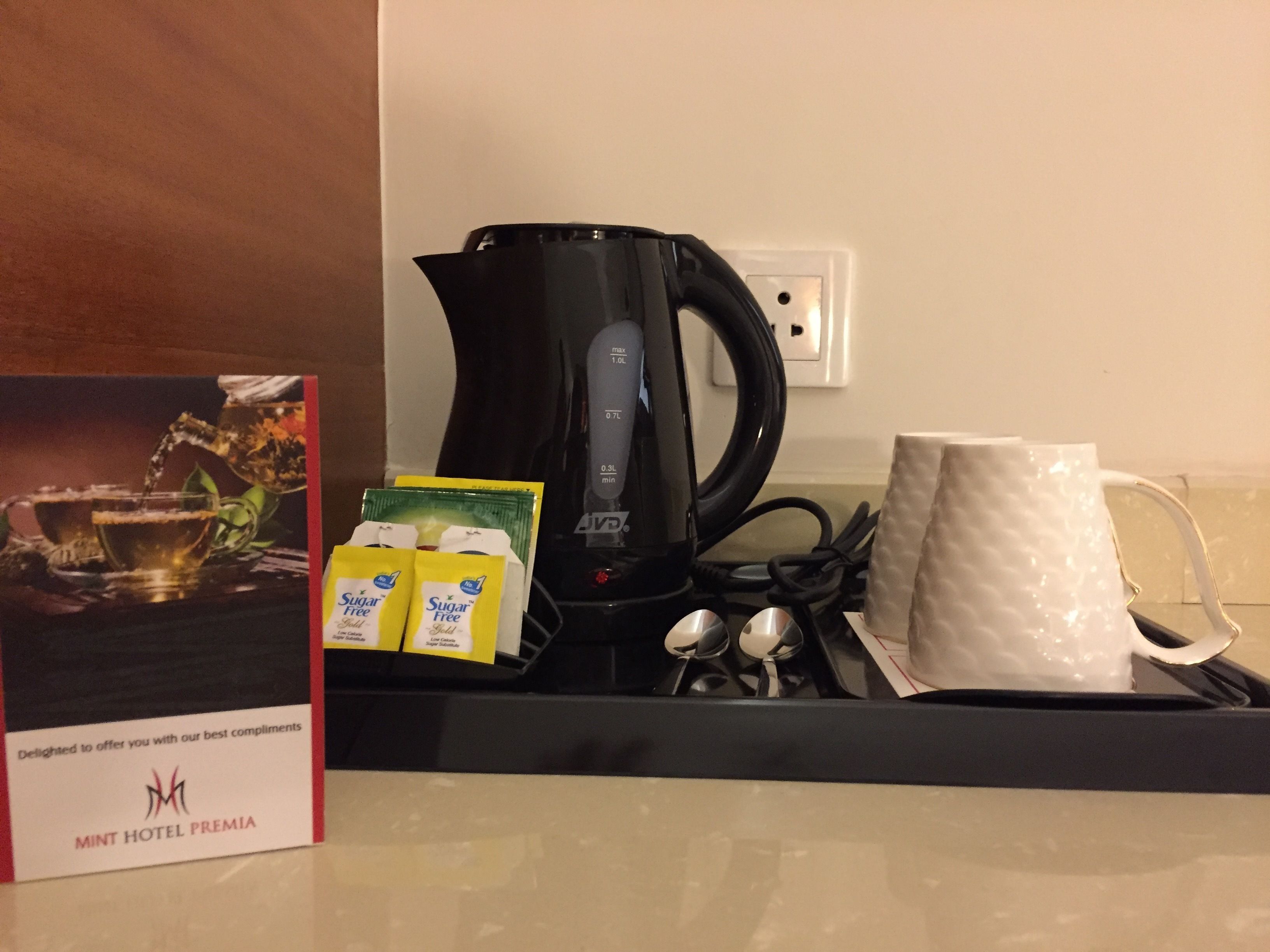 A coffee station with a coffee maker, sugar packets, and a mug.