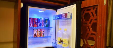 Un refrigerador con revestimiento de madera, que contiene bebidas y aperitivos.