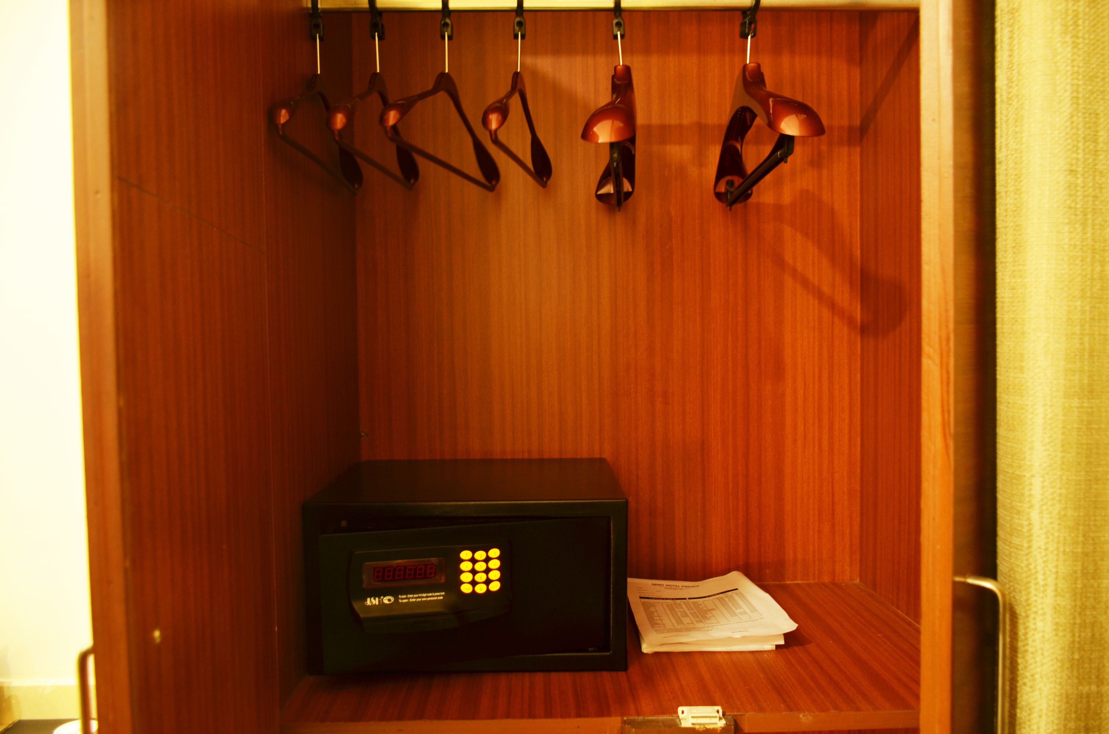 A wooden cabinet with a microwave, a set of keys, and a newspaper on a wooden surface.