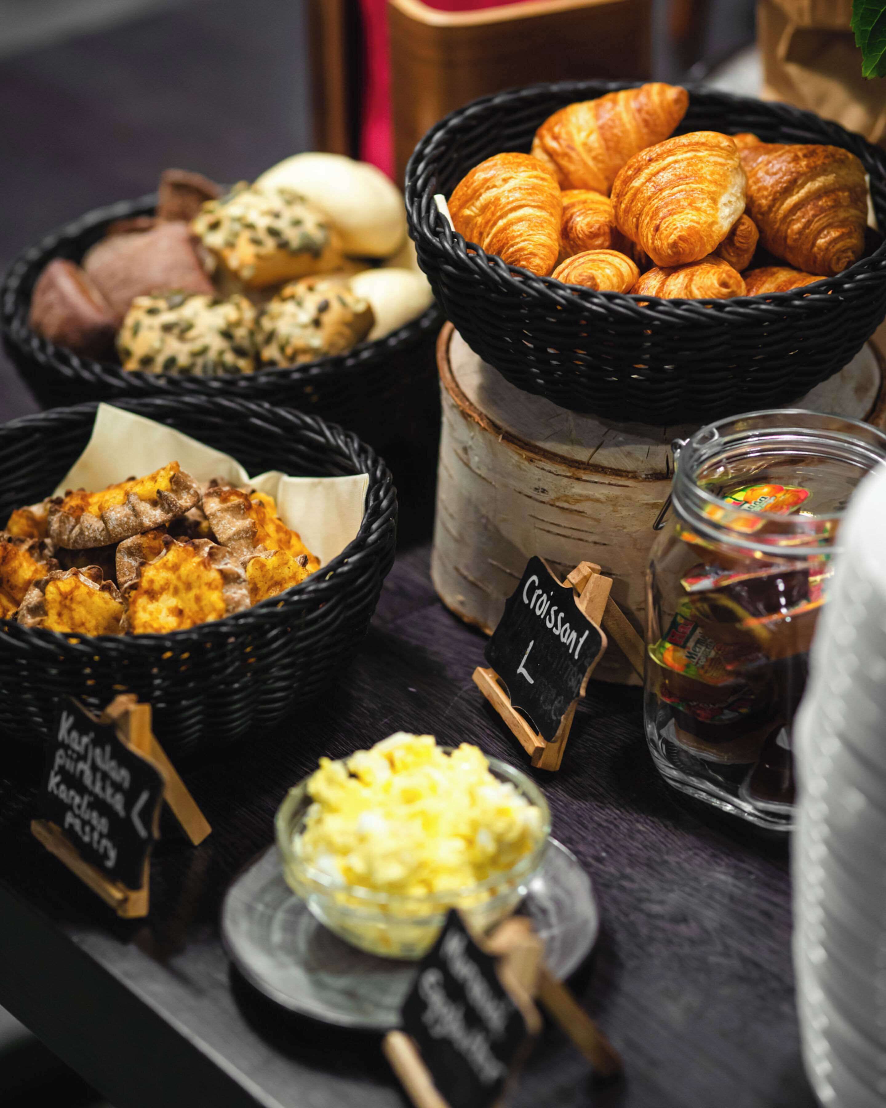 A breakfast buffet with various pastries, bread, and spreads.