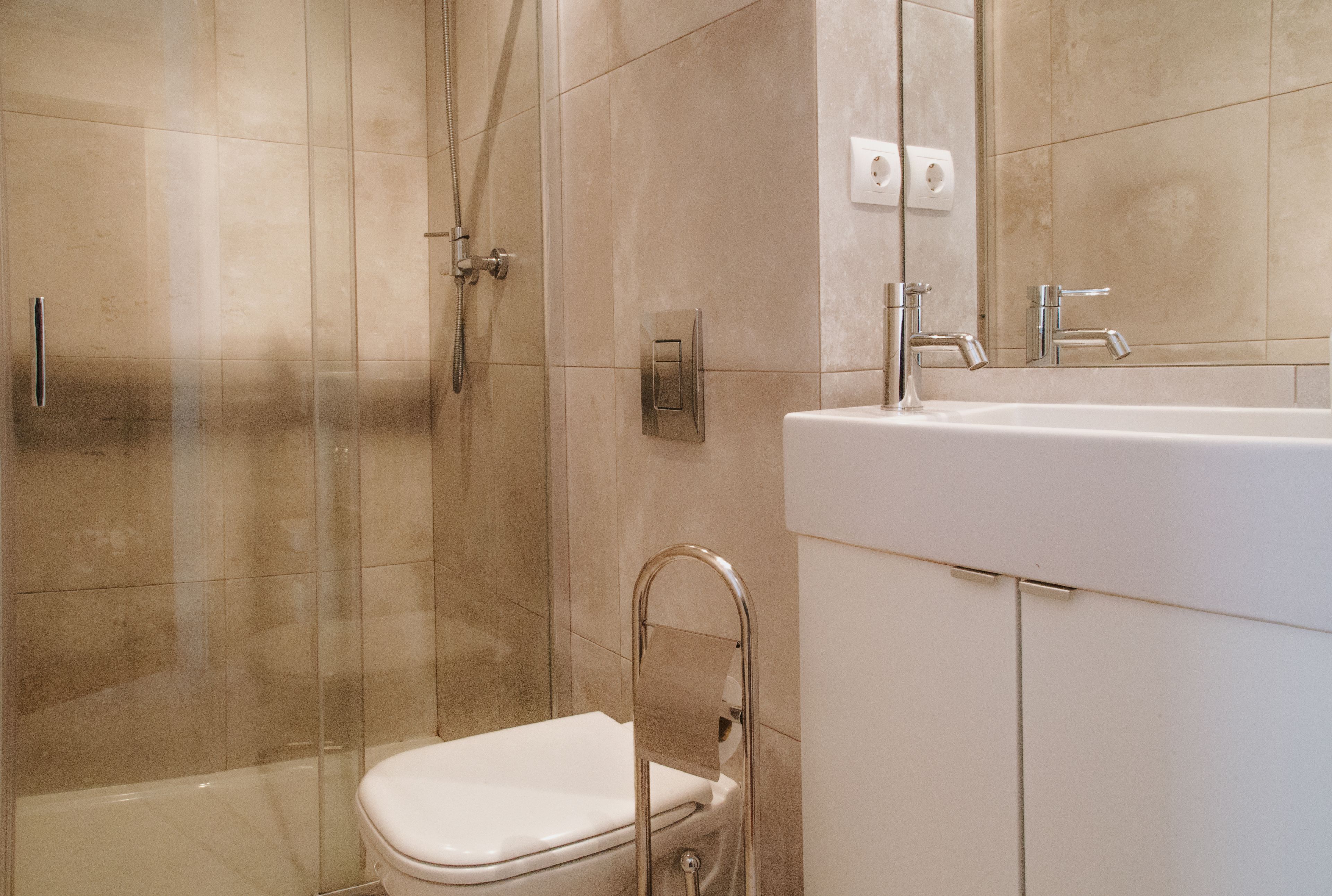 A bathroom with a shower, toilet, and sink.