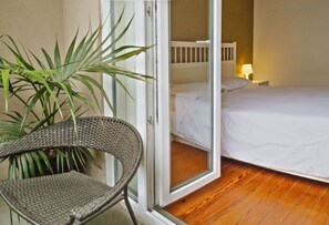 A room with a bed, a chair, and a potted plant. - Porto Spot Hostel (Porto)