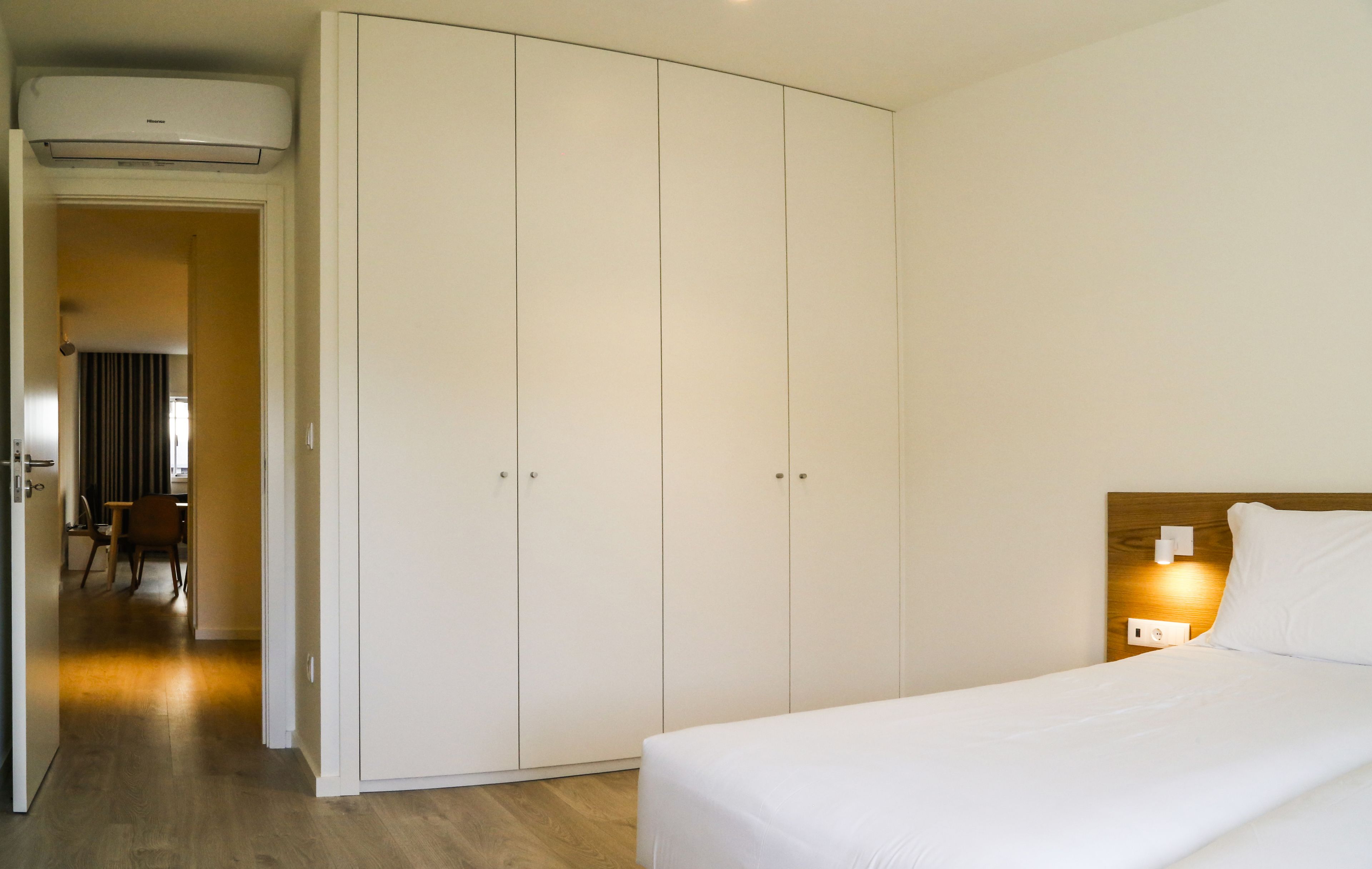 Une chambre d’hôtel avec un lit, une armoire, un bureau et une chaise.