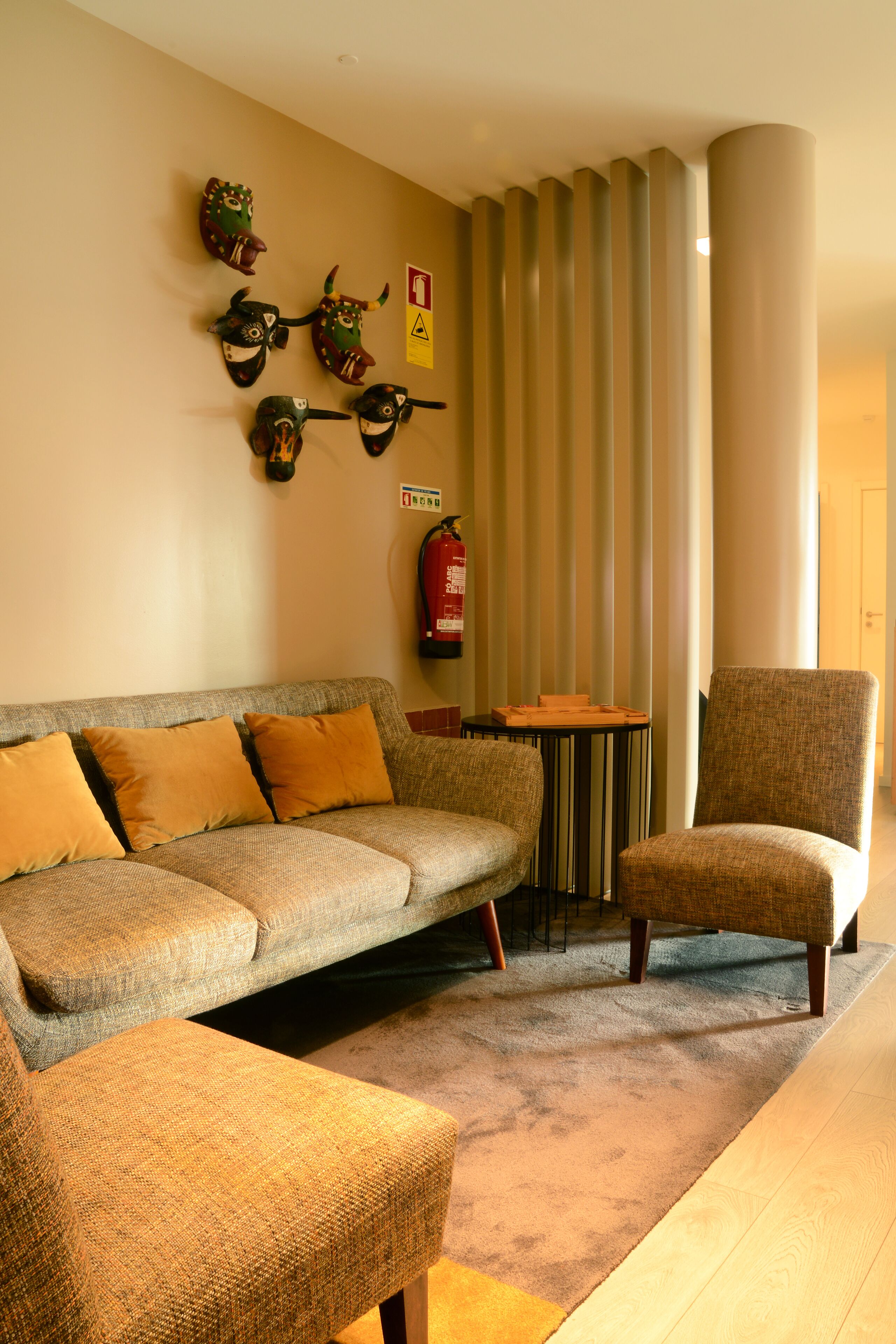 A living room with a sofa, armchair, and a small table.
