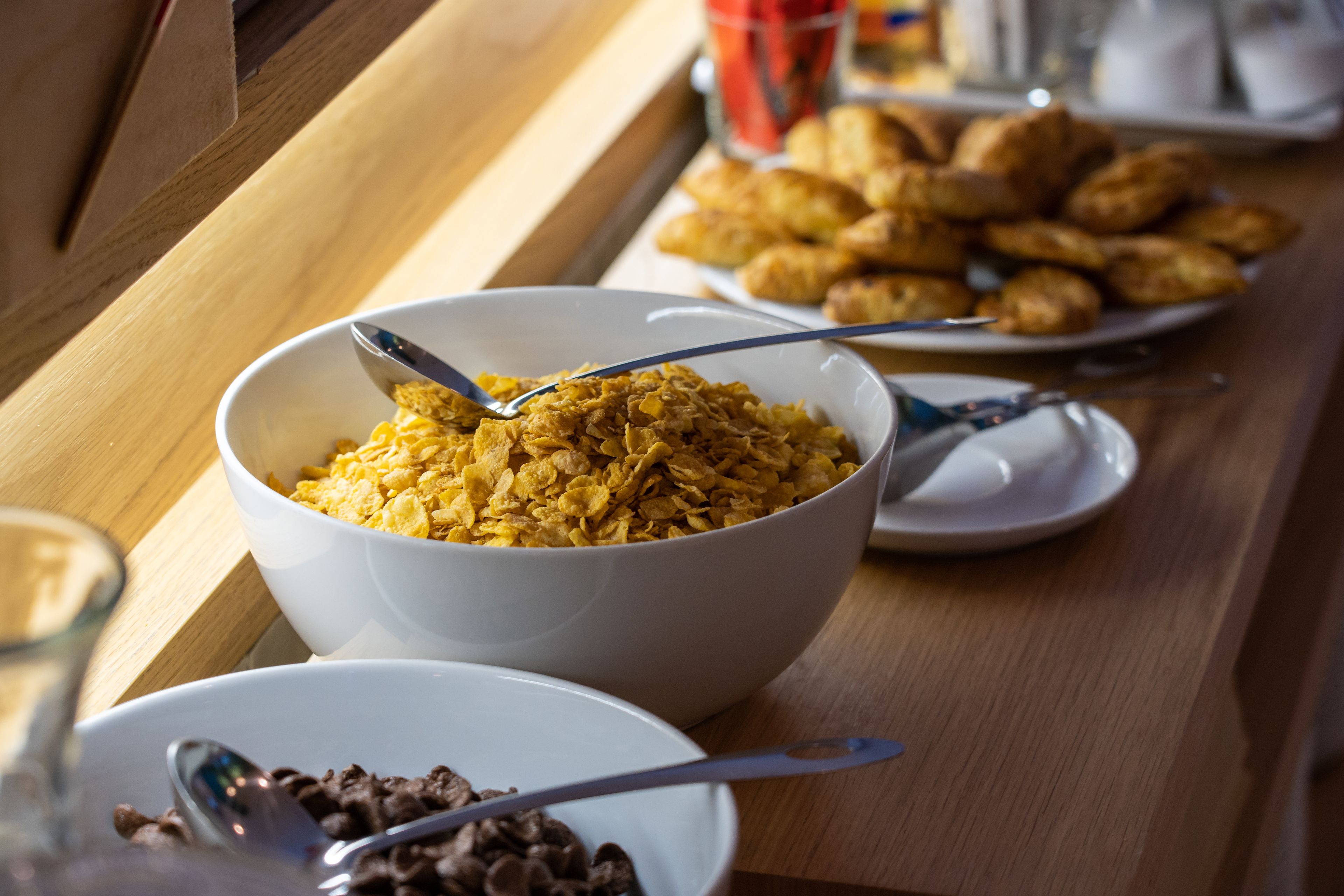 Una tavola per la colazione con ciotole di cereali e dolci.