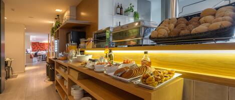 Buffet de l'esmorzar amb diferents aliments i una màquina de cafè.
