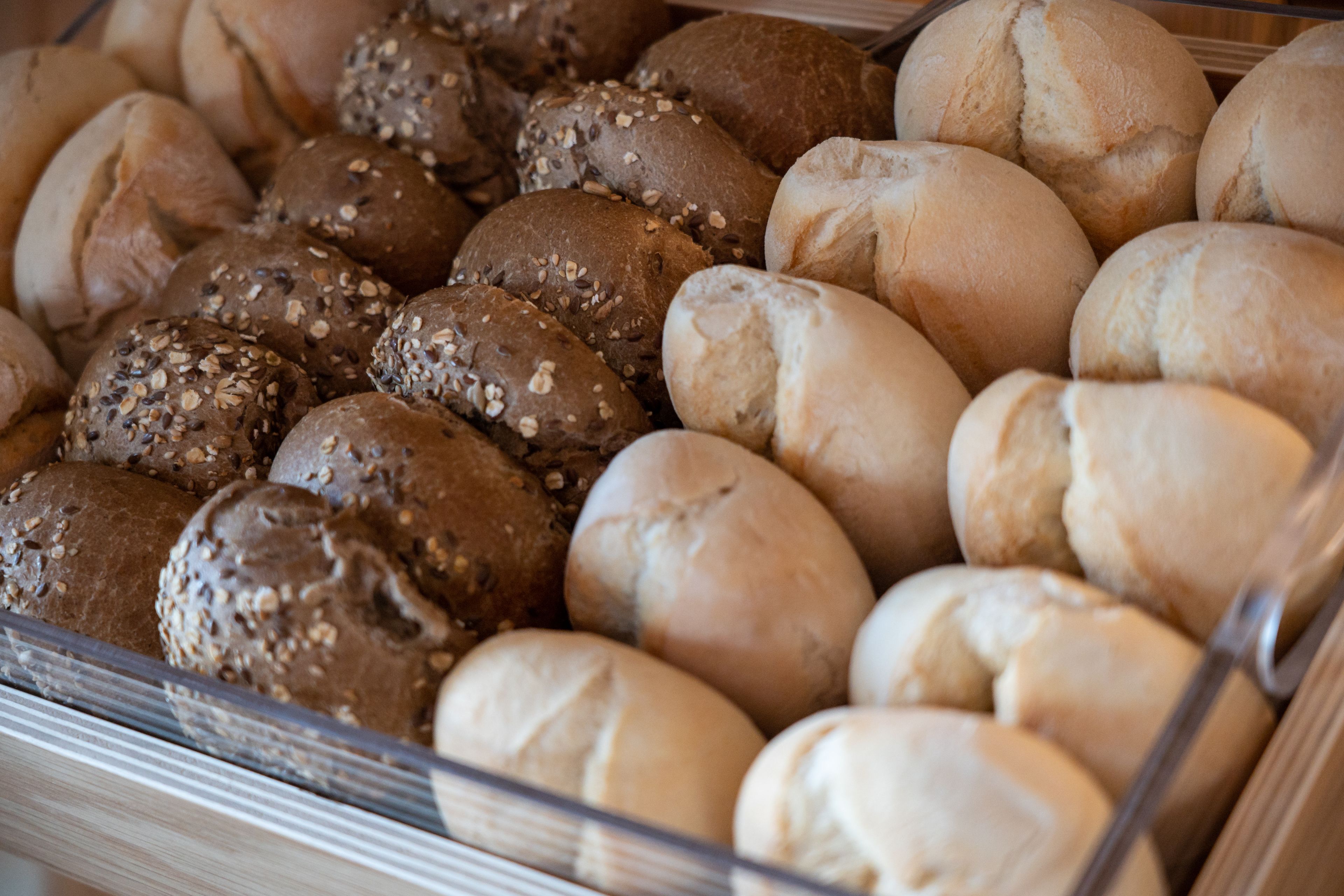 Une variété de pains exposés dans la vitrine d’une boulangerie.