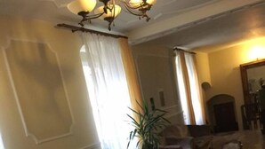 A traditional living room with a sofa, chairs, a table, and a chandelier. - Palac Lasow (Piensk)