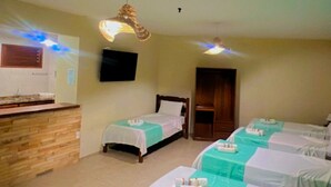 A hotel room with two beds, a wooden counter, a TV, and a ceiling fan. - Hotel Pousada 360° (Paracuru)