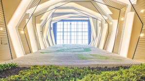 A modern interior with a geometric design, a central open space, and a patterned floor.
