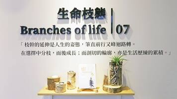 Uma parede com o texto 'Branches of life' e uma prateleira com objetos decorativos.