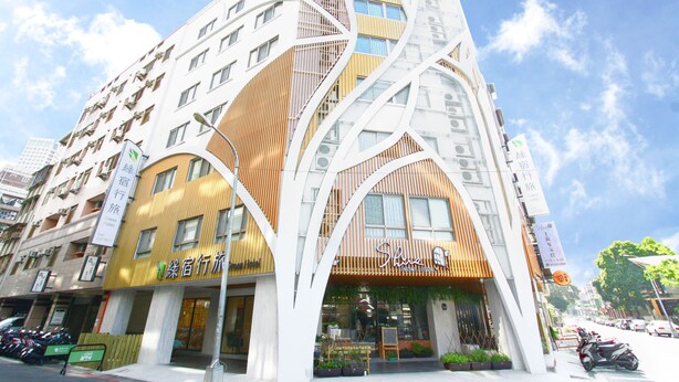 A modern hotel with a unique architectural design, featuring curved lines and a mix of wooden and white facades.