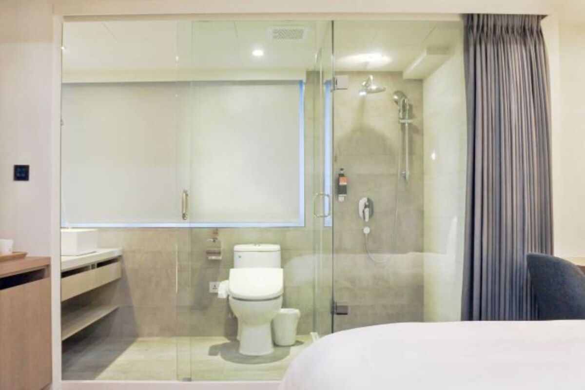 Un baño moderno con ducha de vidrio, inodoro y lavamanos.
