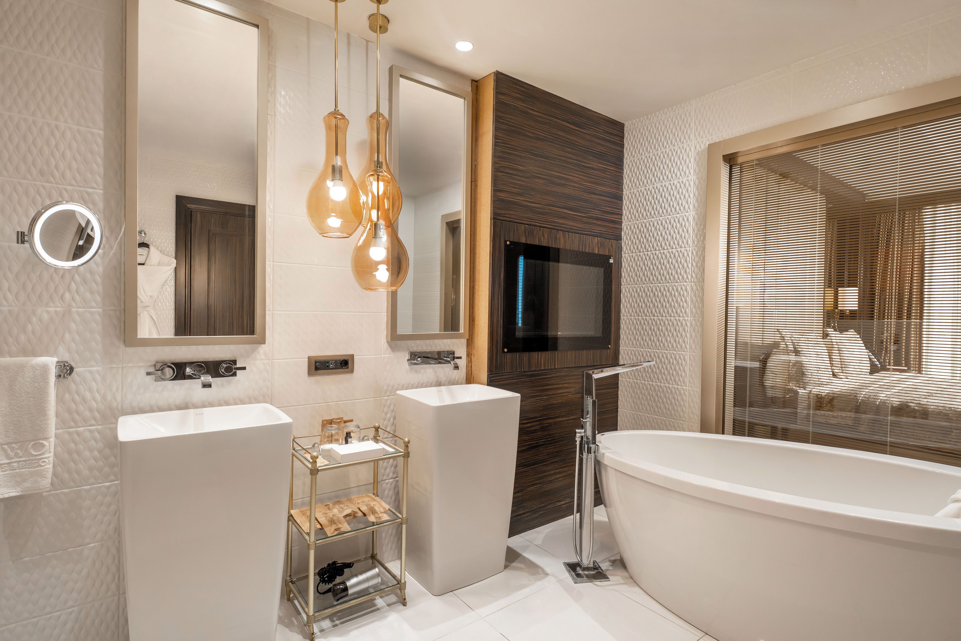 A modern bathroom with a freestanding bathtub, two sinks, a vanity, and a mirror.