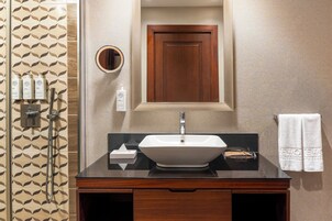 A bathroom with a sink, mirror, and toiletries.