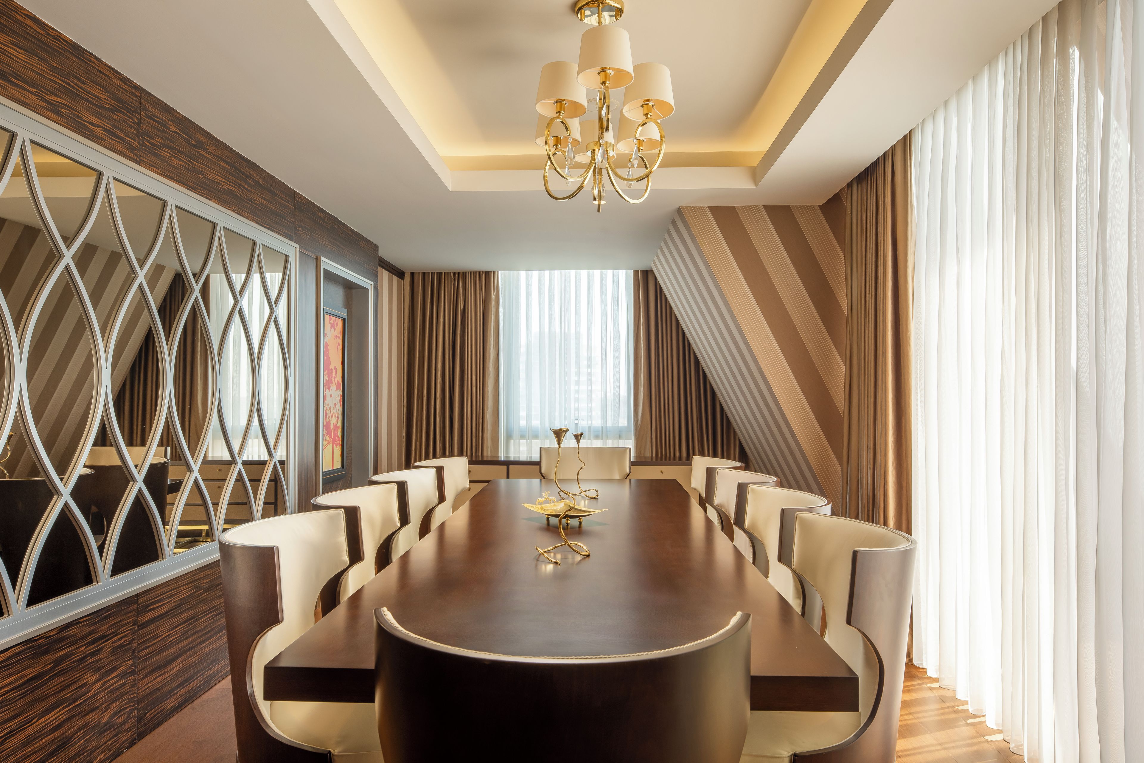 A conference room with a long table, chairs, and a chandelier.