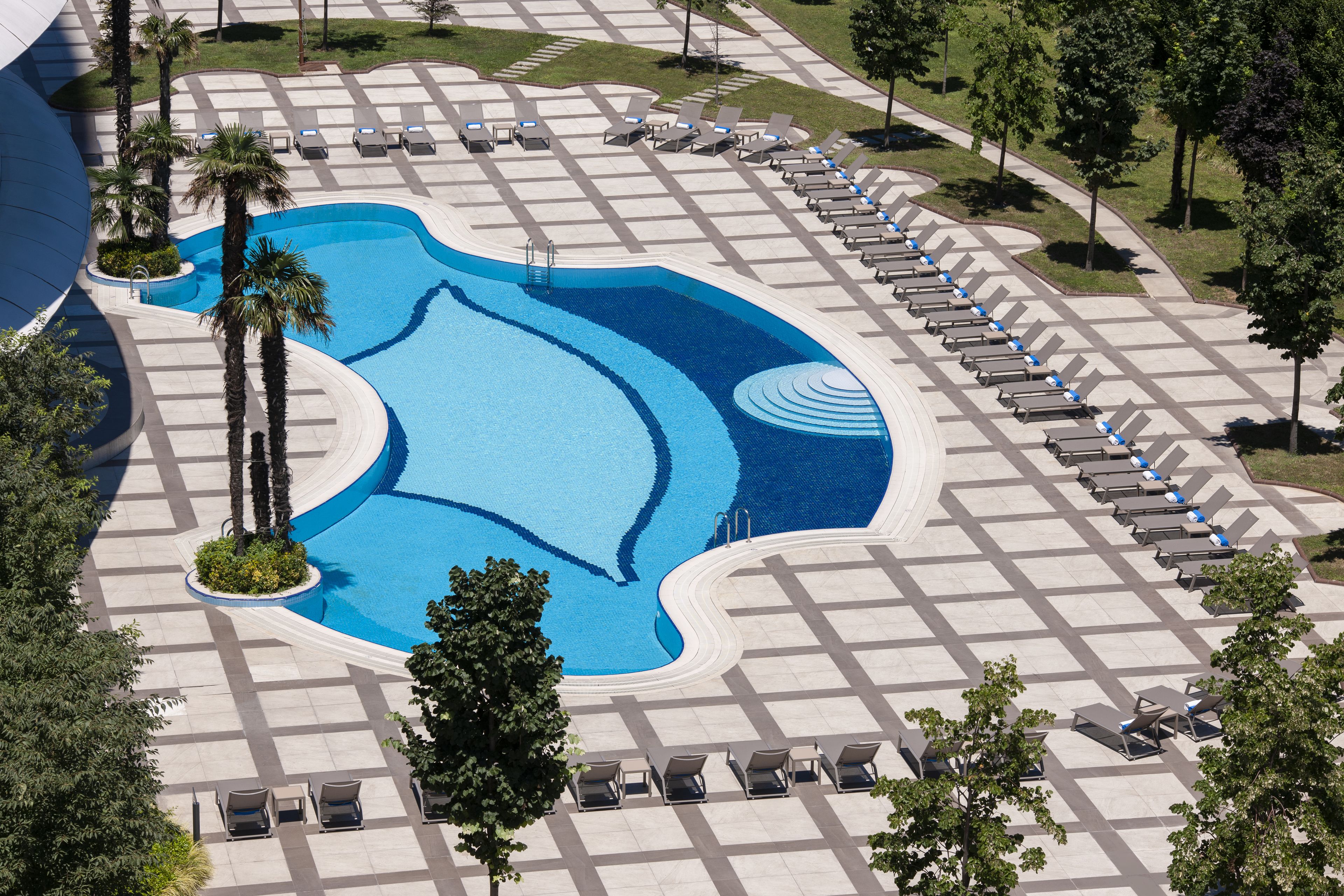 Una piscina techada, una piscina al aire libre de temporada, sombrillas
