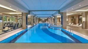 A long indoor swimming pool with exercise equipment on one side and lounge chairs on the other. - Elite World Grand Istanbul Basın Ekspres  (Istanbul)