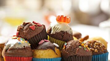 Une variété de petits gâteaux décorés, présentés dans des caissettes en papier de différentes couleurs.